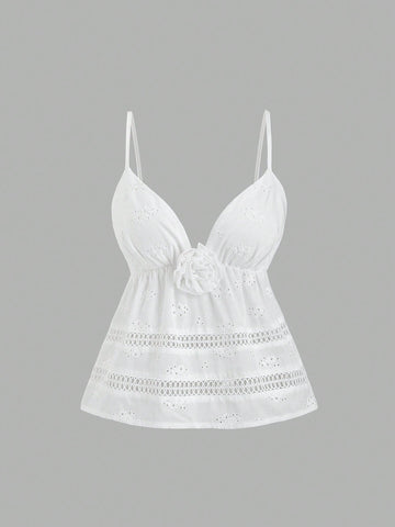 Women's white spaghetti strap cami top with eyelet embroidery, knot detail, ruffle hem, and flared hem shape