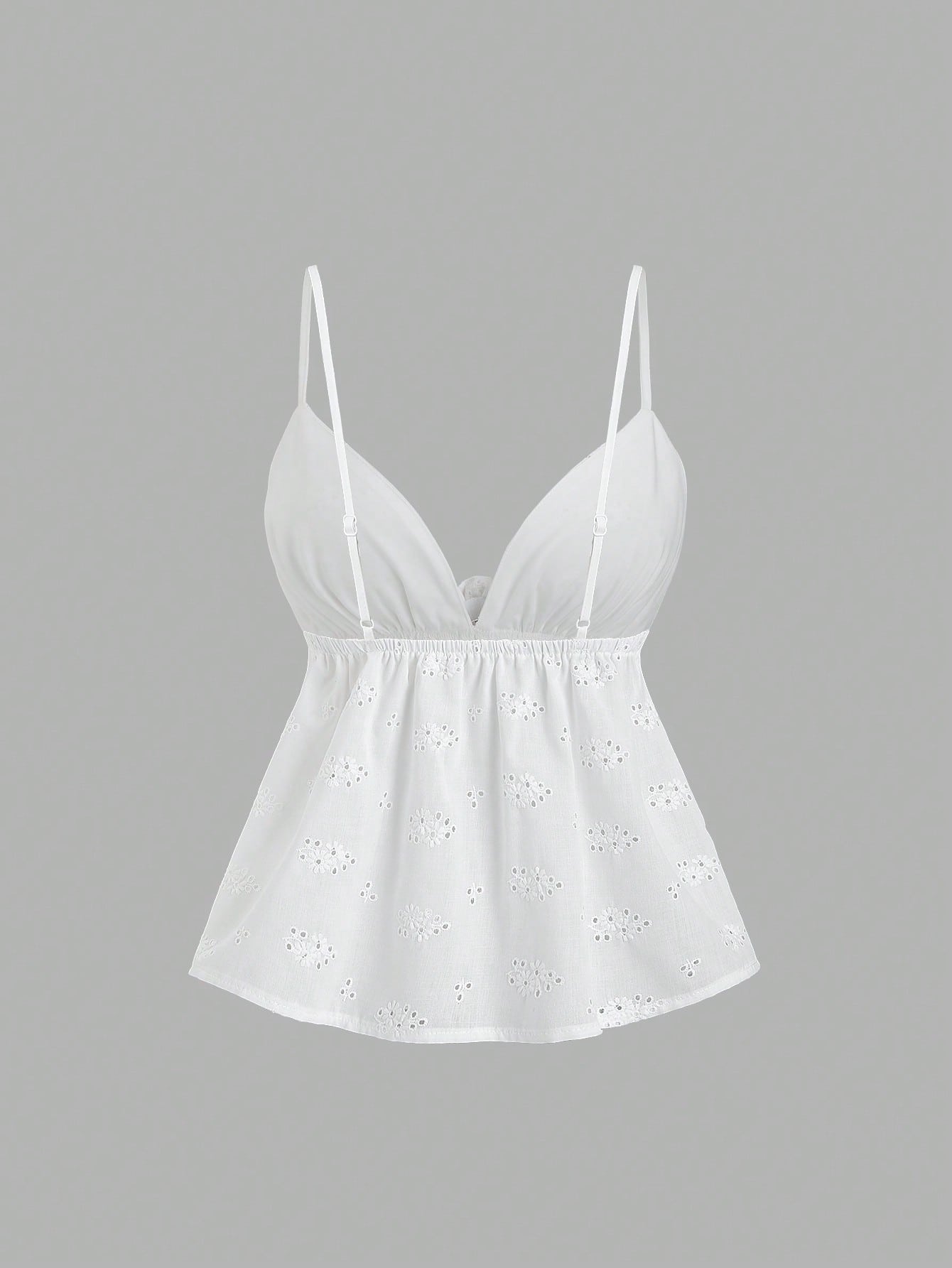 Women's white spaghetti strap cami top with eyelet embroidery, knot detail, ruffle hem, and flared hem shape