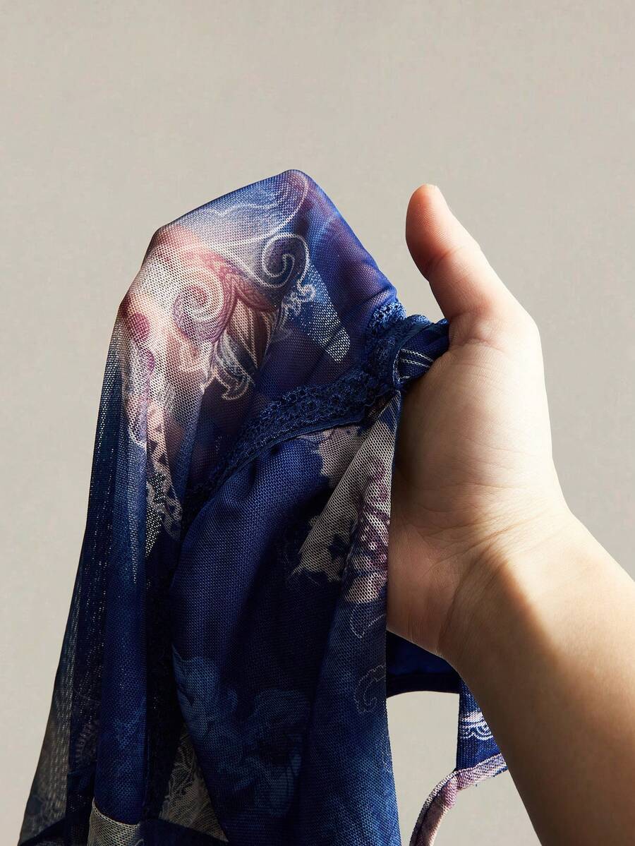 Women's graphic print camisole top featuring thin spaghetti straps, a backless cut, and an asymmetrical hem.