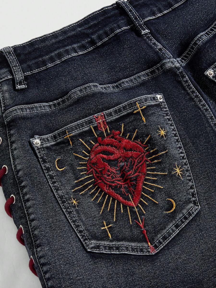 Plus size black gothic mini shorts with heart embroidery, graphic pocket pattern, lace-up detail, raw hem, and zipper fly