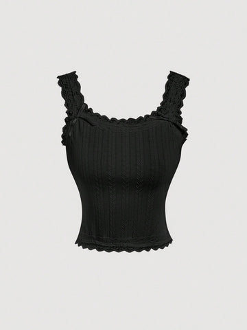 Black jacquard textured camisole top featuring contrast lace trim, bow decoration, scoop neck, and wide shoulder straps.