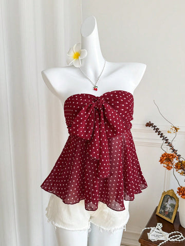 Women's polka dot strapless bandeau crop top with tie bow detail, asymmetrical shirring, and a flared hem.