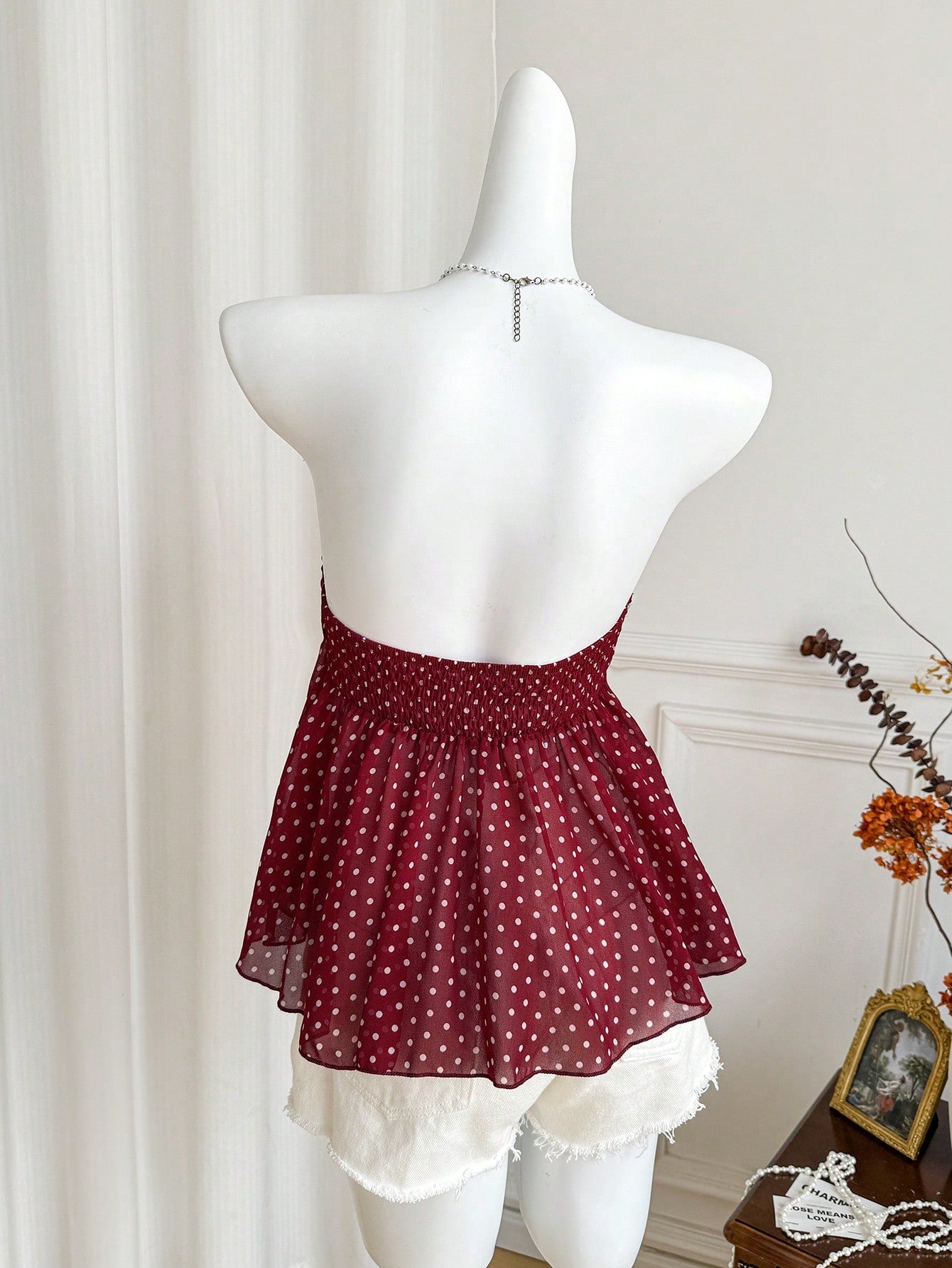 Women's polka dot strapless bandeau crop top with tie bow detail, asymmetrical shirring, and a flared hem.