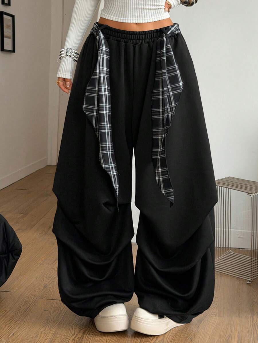 Loose-fitting black baggy parachute pants featuring an elastic drawstring waistband and wide-leg cut made from cotton blend fabric.