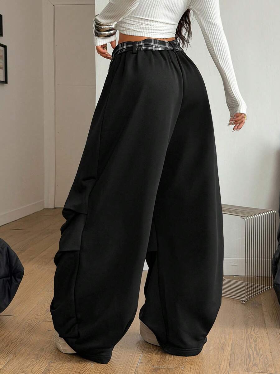 Loose-fitting black baggy parachute pants featuring an elastic drawstring waistband and wide-leg cut made from cotton blend fabric.