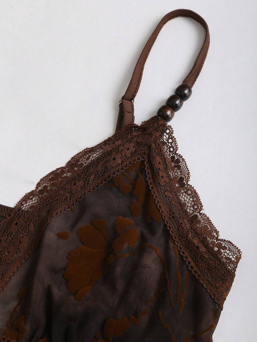 Women's black spaghetti strap tank top featuring contrast lace details, asymmetric ruffle hem, and slim fit design.
