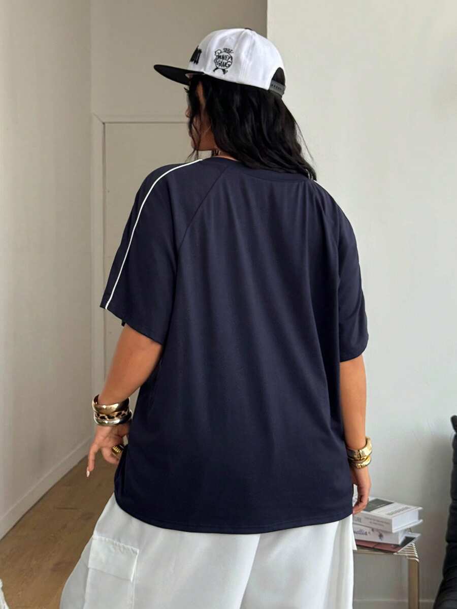 Unisex plus size oversized jersey t-shirt in brown featuring a round neck, short raglan sleeves with contrast binding, and a front letter graphic print.