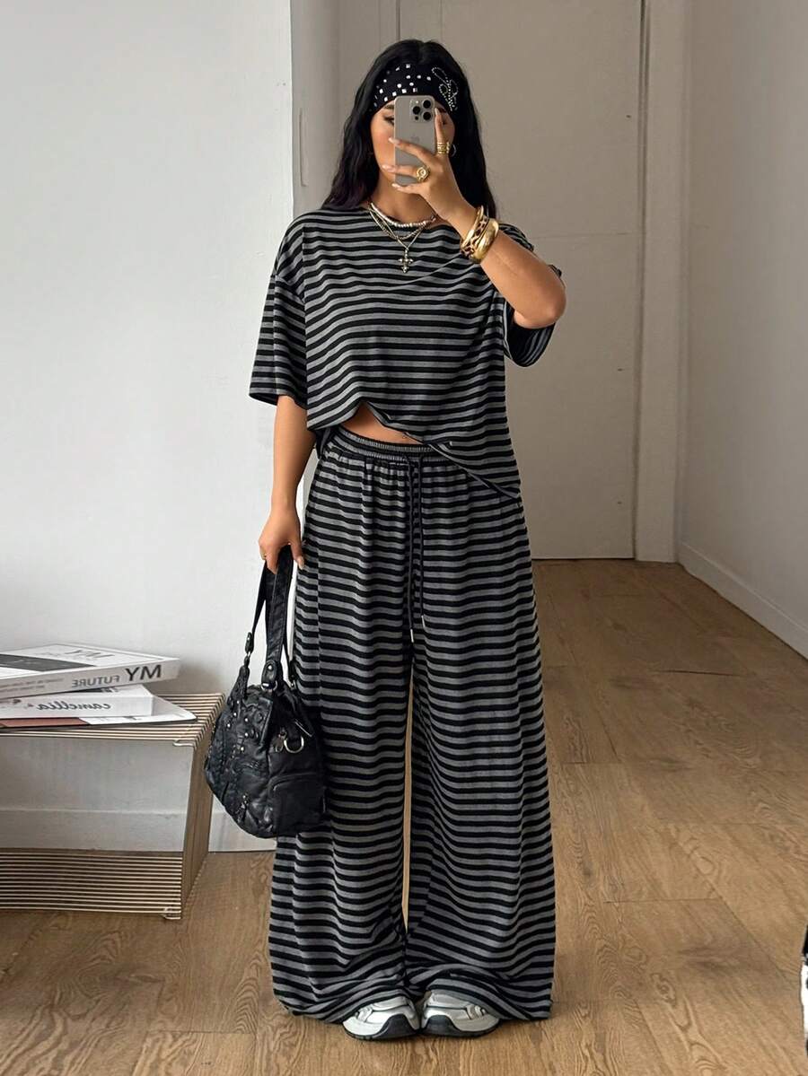 Women's casual two-piece outfit featuring a loose short-sleeve asymmetrical neck t-shirt and matching long wide leg pants with pockets.