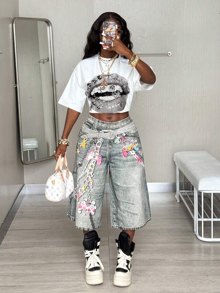 Front view of a women's black oversized crop t-shirt with pink lips graphic, round neckline, and short drop-shoulder sleeves.