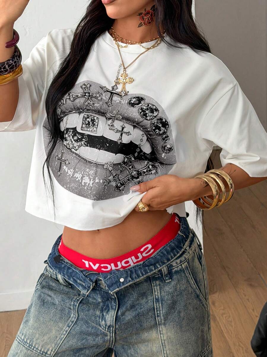 Front view of a women's black oversized crop t-shirt with pink lips graphic, round neckline, and short drop-shoulder sleeves.