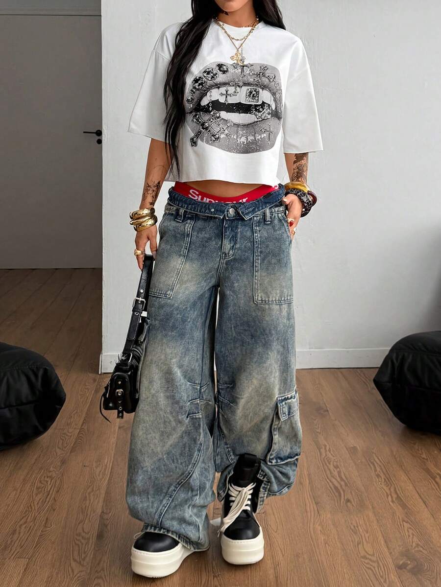 Front view of a women's black oversized crop t-shirt with pink lips graphic, round neckline, and short drop-shoulder sleeves.