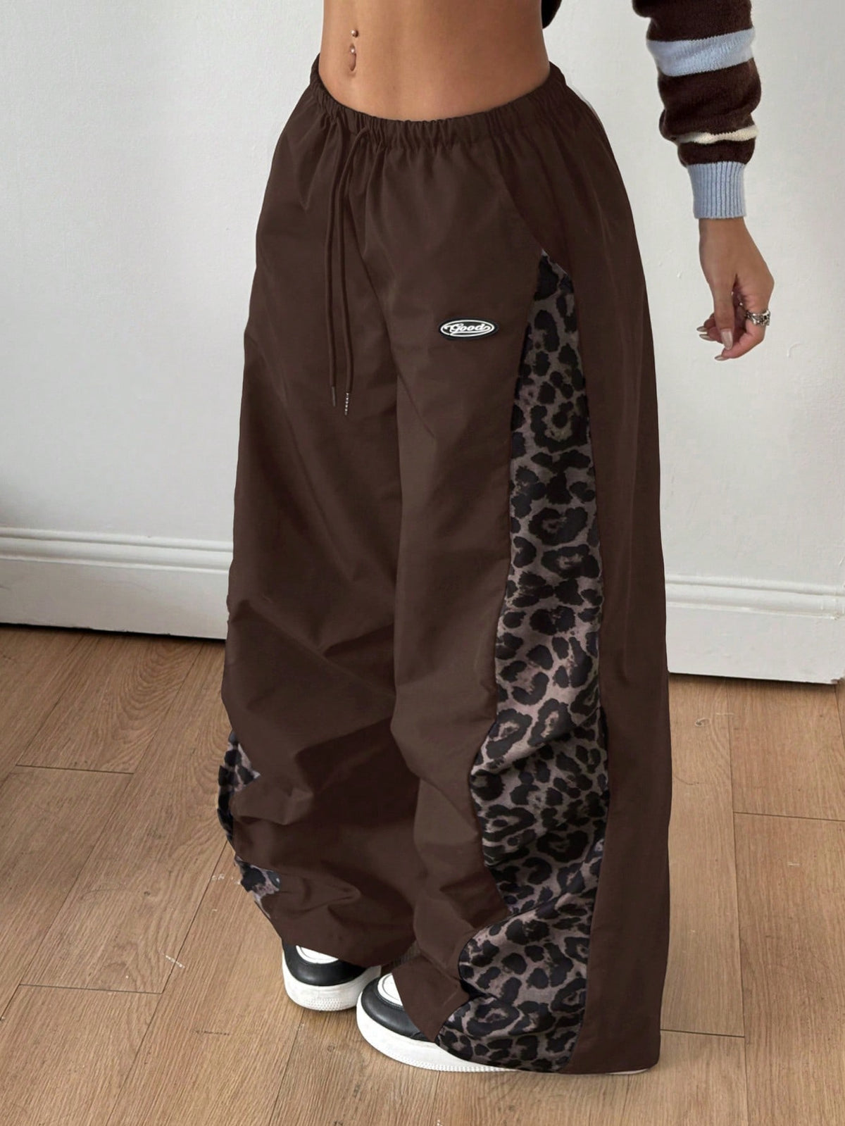 Women's black baggy jogger pants with an adjustable drawstring waist and colorblock polka dot geometric pattern.