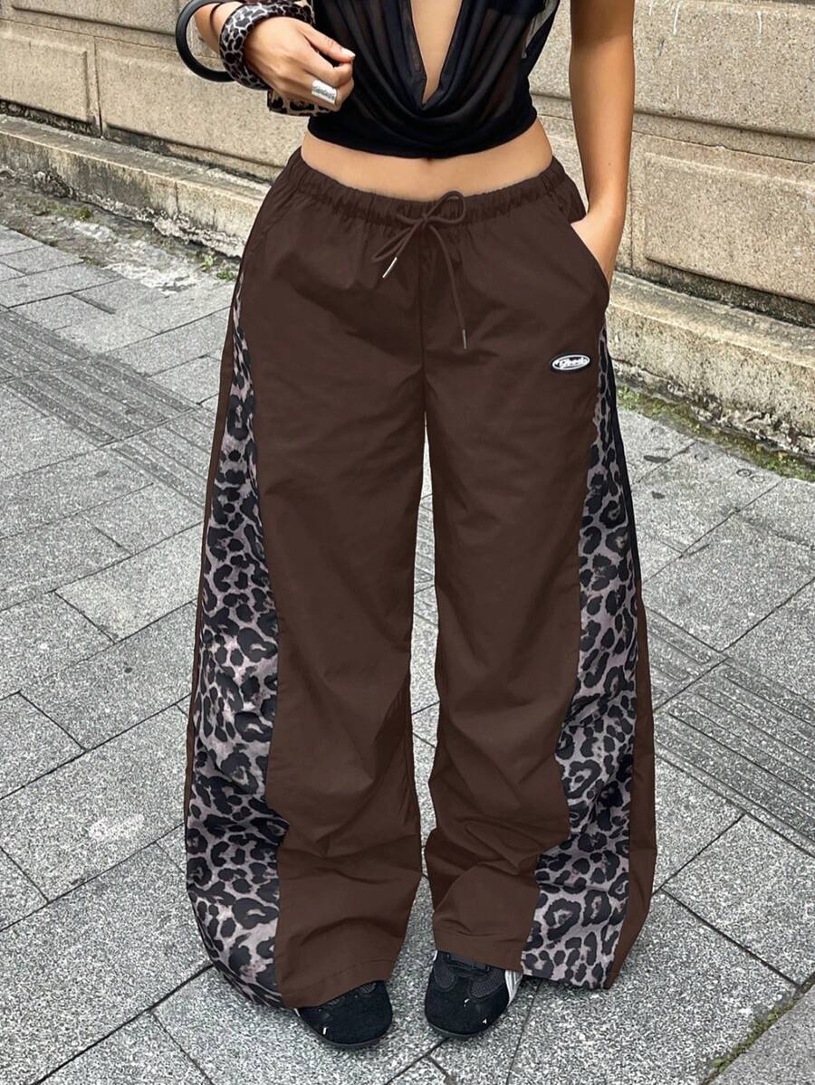 Women's black baggy jogger pants with an adjustable drawstring waist and colorblock polka dot geometric pattern.