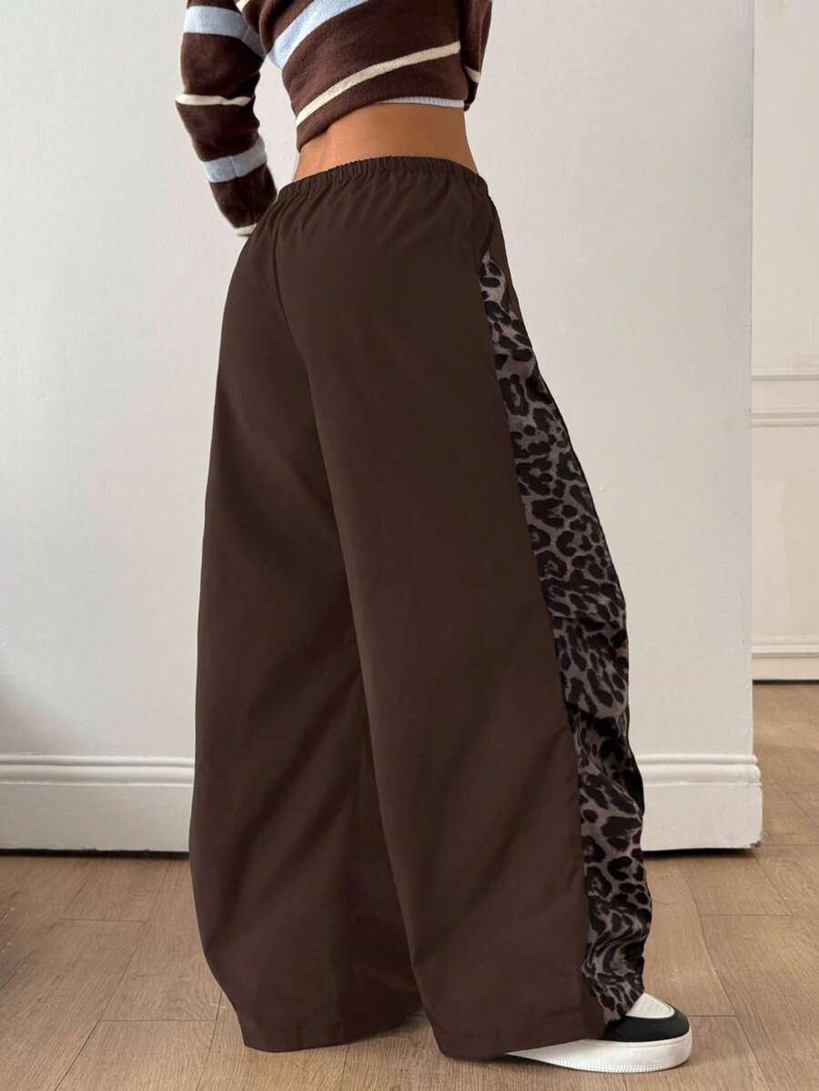 Women's black baggy jogger pants with an adjustable drawstring waist and colorblock polka dot geometric pattern.