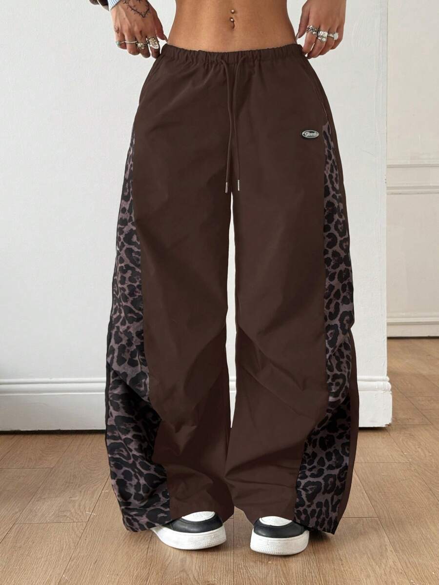 Women's black baggy jogger pants with an adjustable drawstring waist and colorblock polka dot geometric pattern.