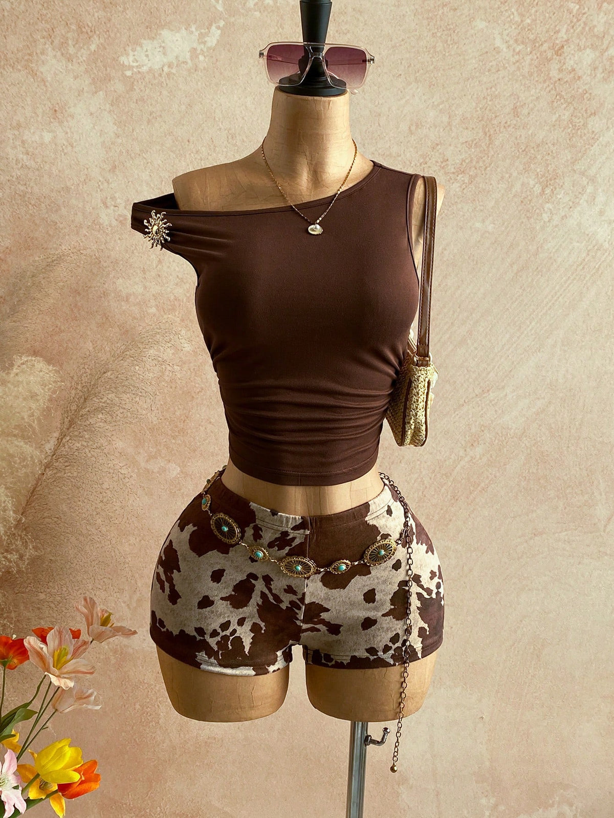 Women's black fuzzy knit two-piece set with an asymmetrical crop camisole top featuring ruched detail and cutout back, paired with matching mini shorts.