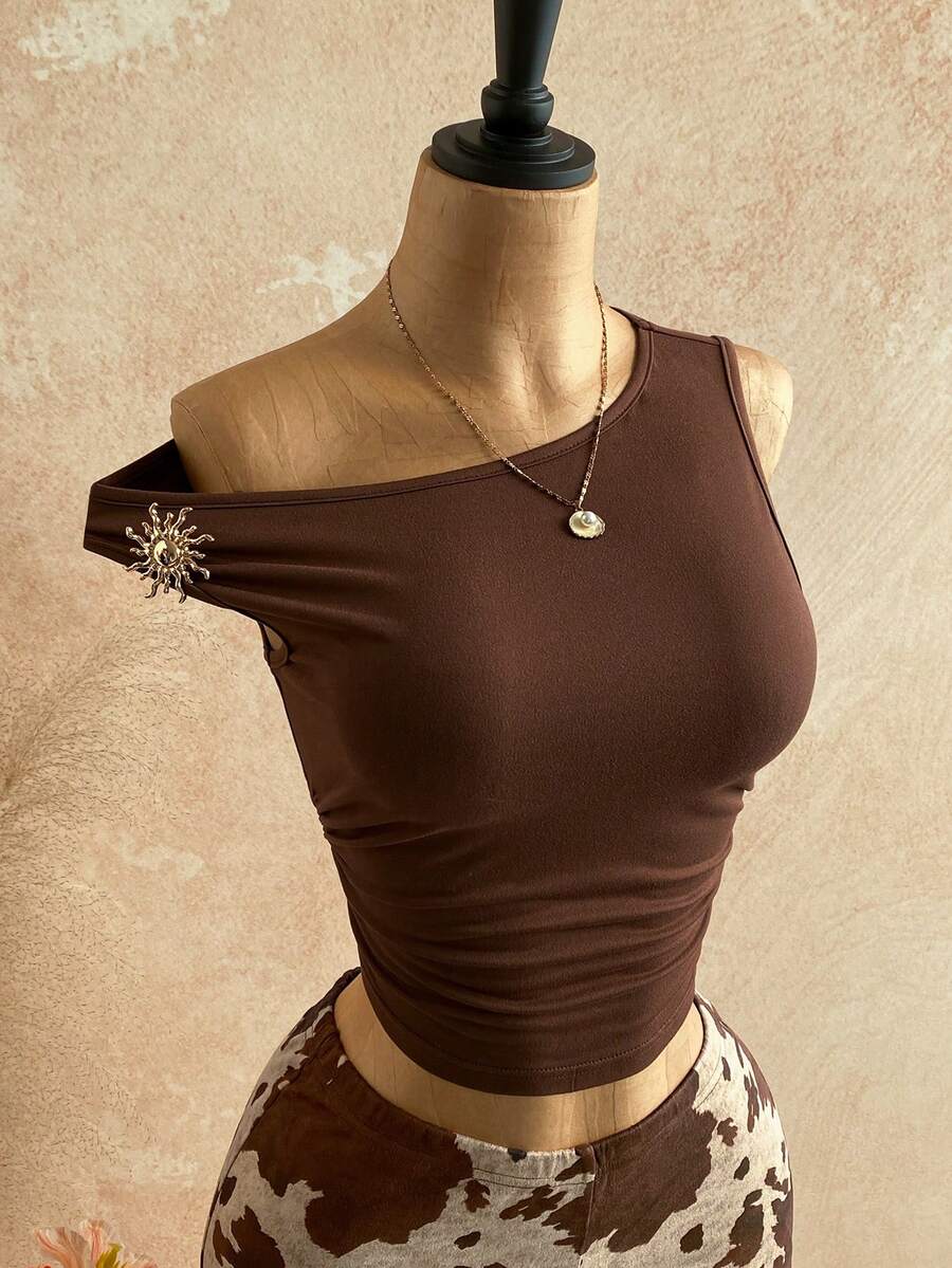 Women's black fuzzy knit two-piece set with an asymmetrical crop camisole top featuring ruched detail and cutout back, paired with matching mini shorts.
