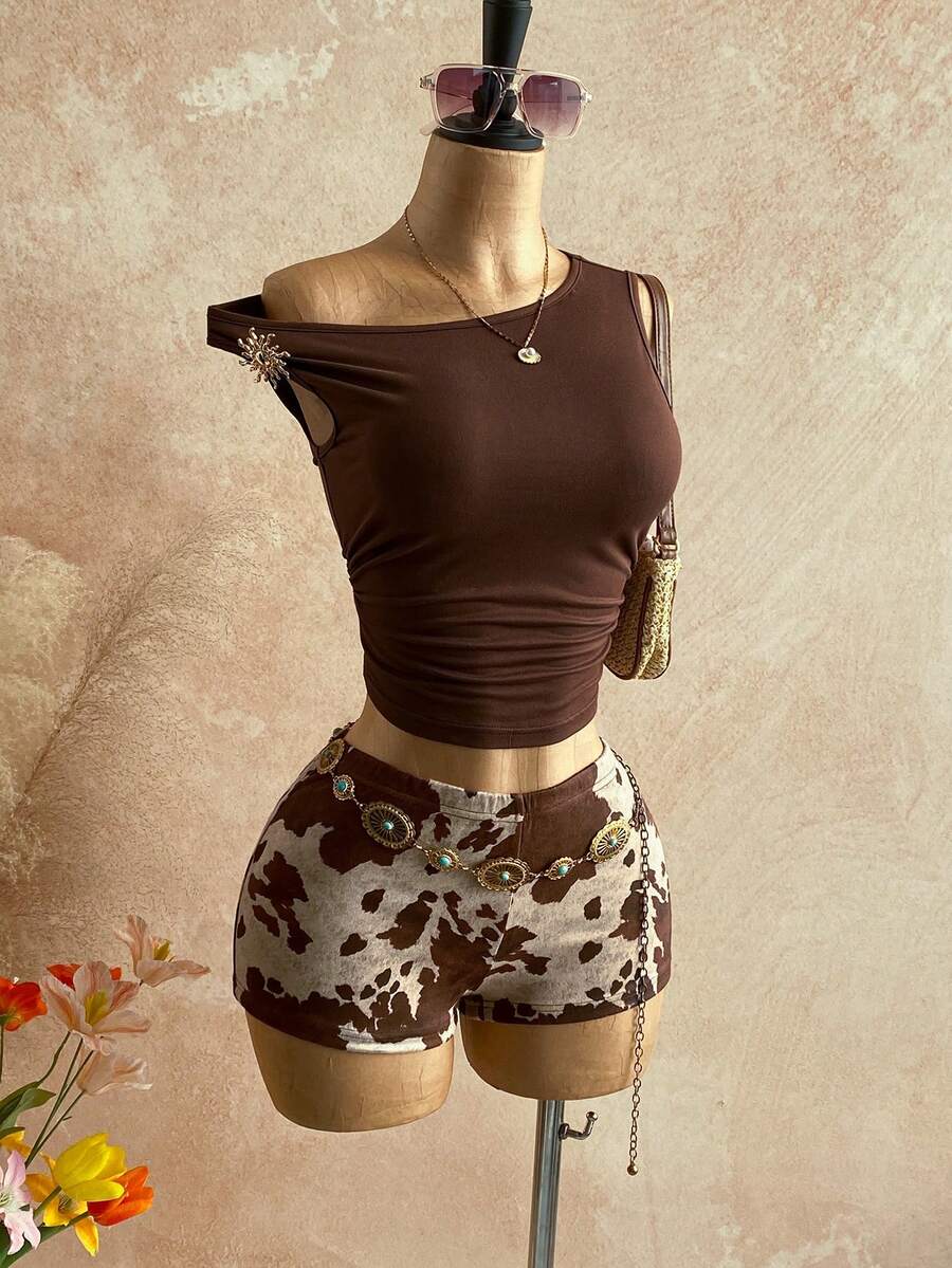 Women's black fuzzy knit two-piece set with an asymmetrical crop camisole top featuring ruched detail and cutout back, paired with matching mini shorts.