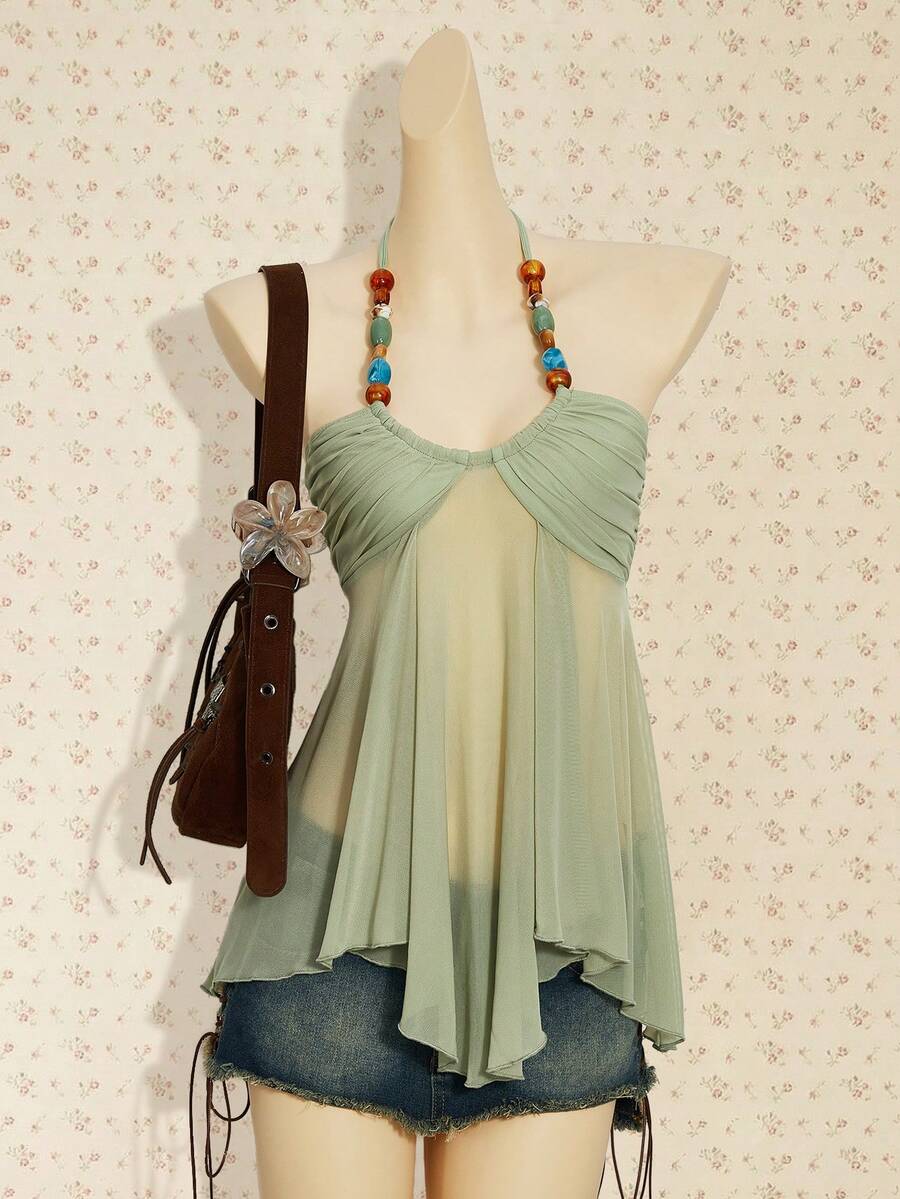 Women's boho halter mesh tank top with asymmetrical hem, semi-sheer finish, lined body, slim fit, and cold shoulder styling.