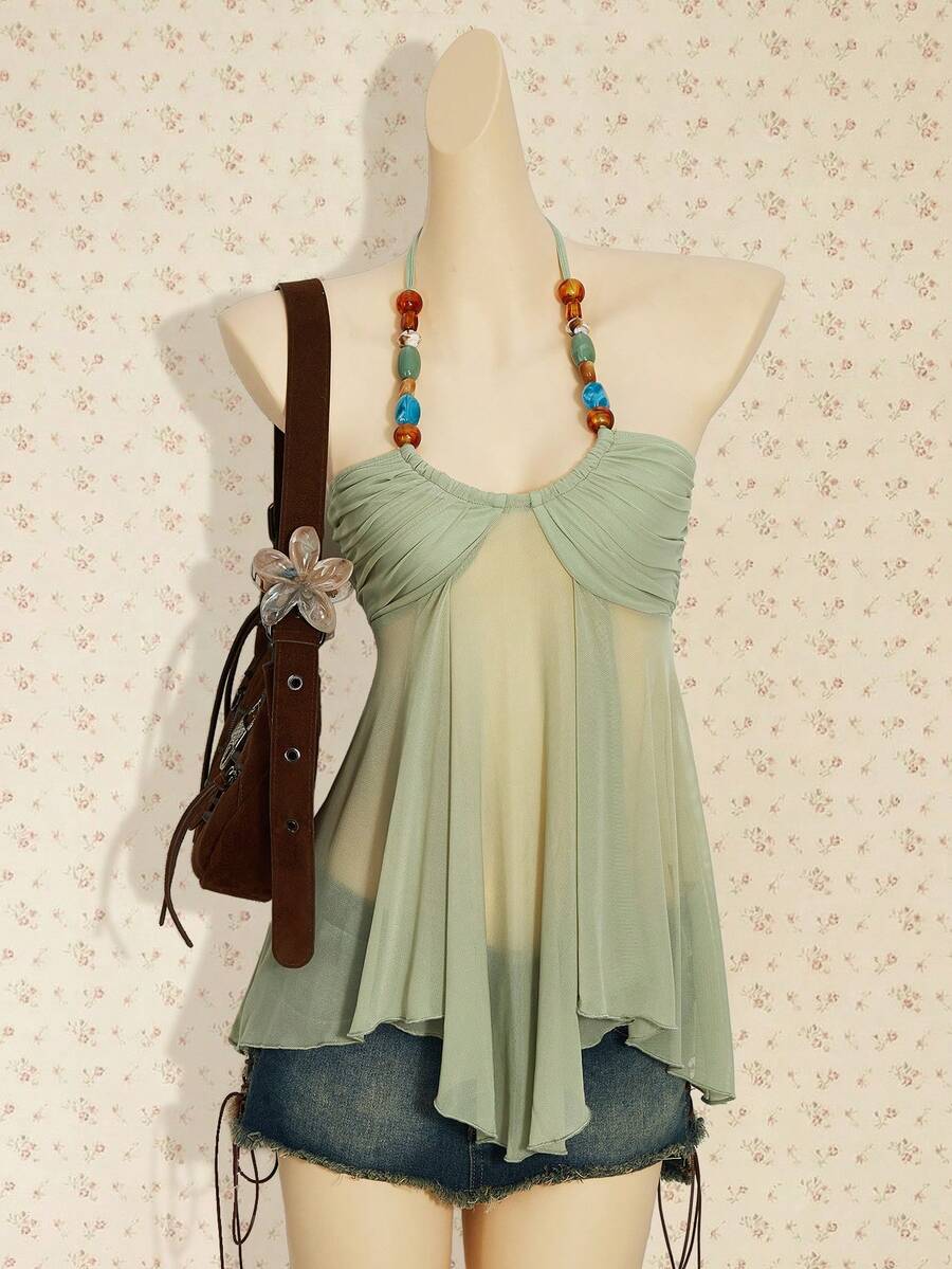 Women's boho halter mesh tank top with asymmetrical hem, semi-sheer finish, lined body, slim fit, and cold shoulder styling.