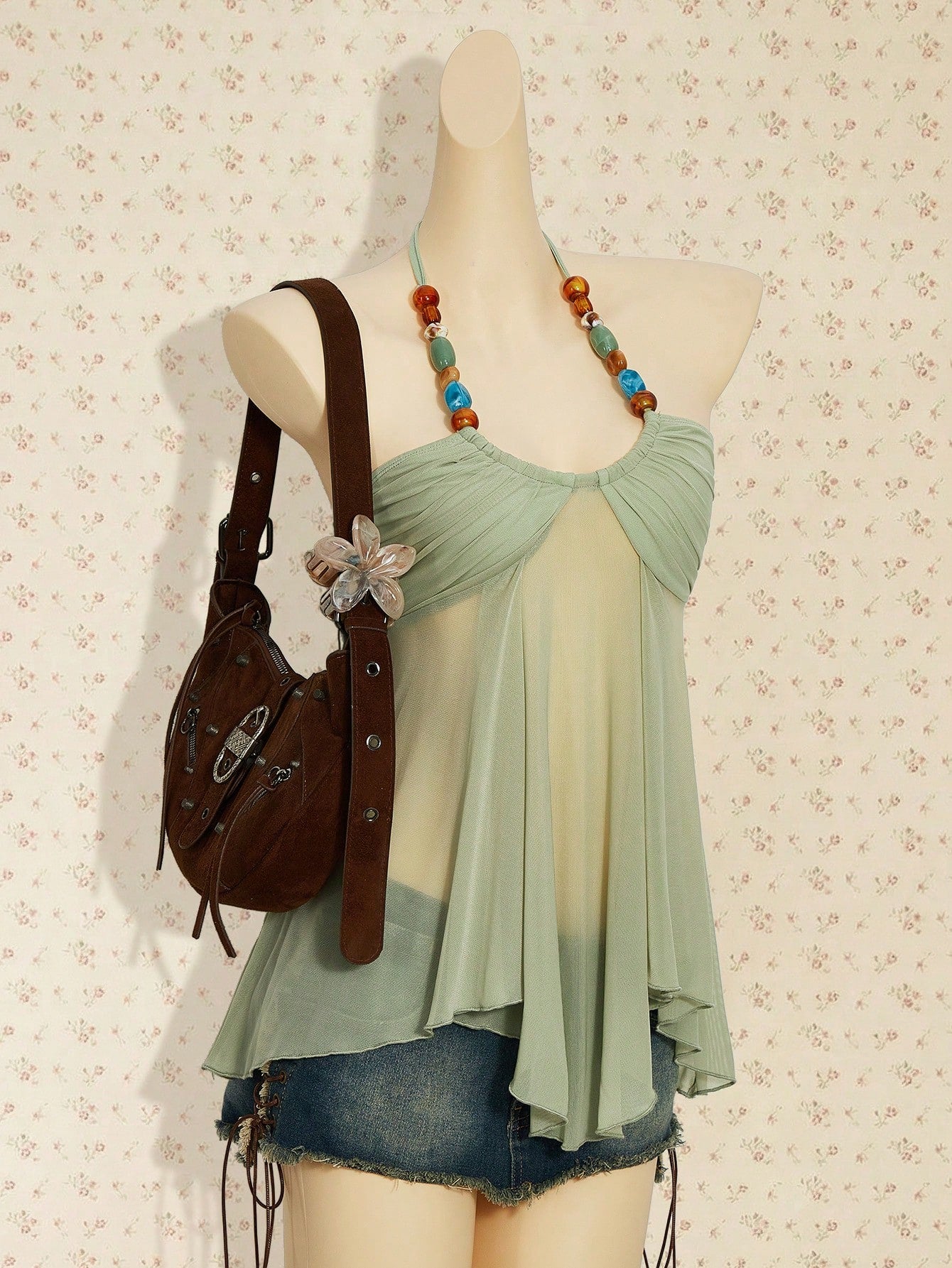 Women's boho halter mesh tank top with asymmetrical hem, semi-sheer finish, lined body, slim fit, and cold shoulder styling.