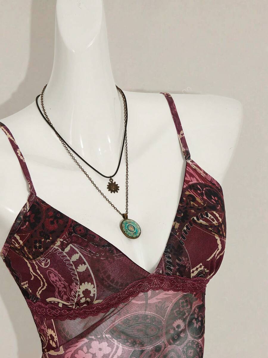 Women's graphic print camisole top featuring thin spaghetti straps, a backless cut, and an asymmetrical hem.