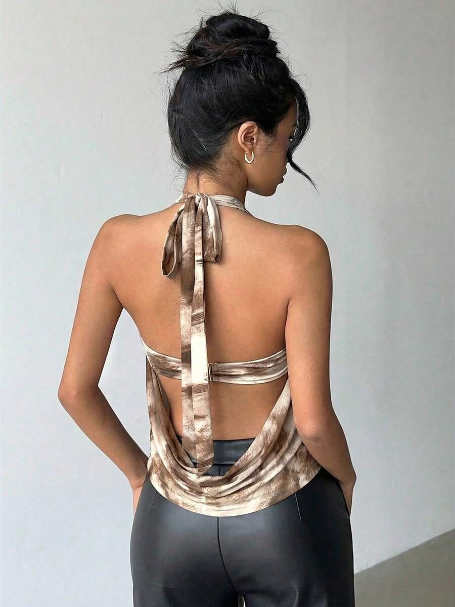 Brown and white polka dot semi-sheer halter camisole top with a plunging neckline, backless design, draped front, and metallic studded embellishments.