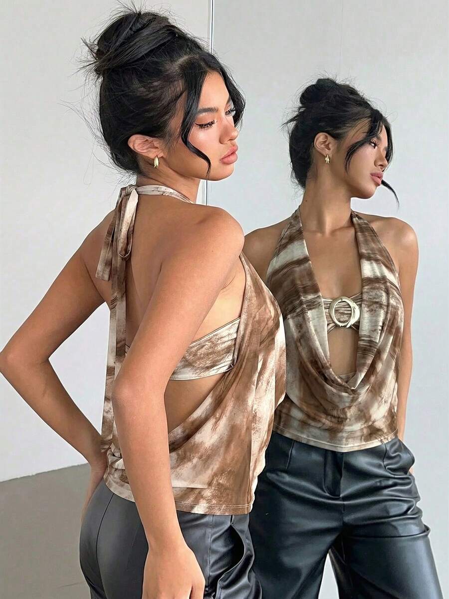 Brown and white polka dot semi-sheer halter camisole top with a plunging neckline, backless design, draped front, and metallic studded embellishments.