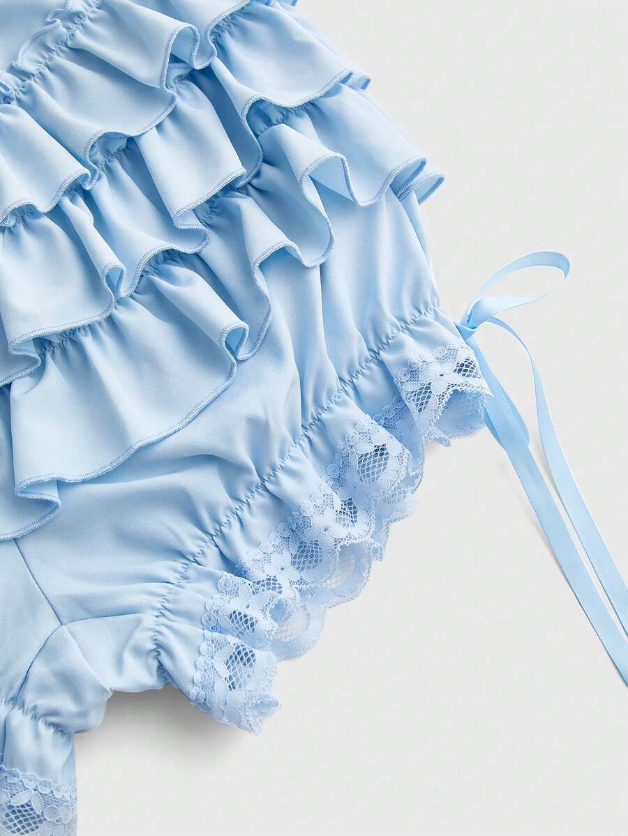 Women's tiered ruffle skort shorts featuring an elastic mid waist with front tie knot detail in woven fabric.
