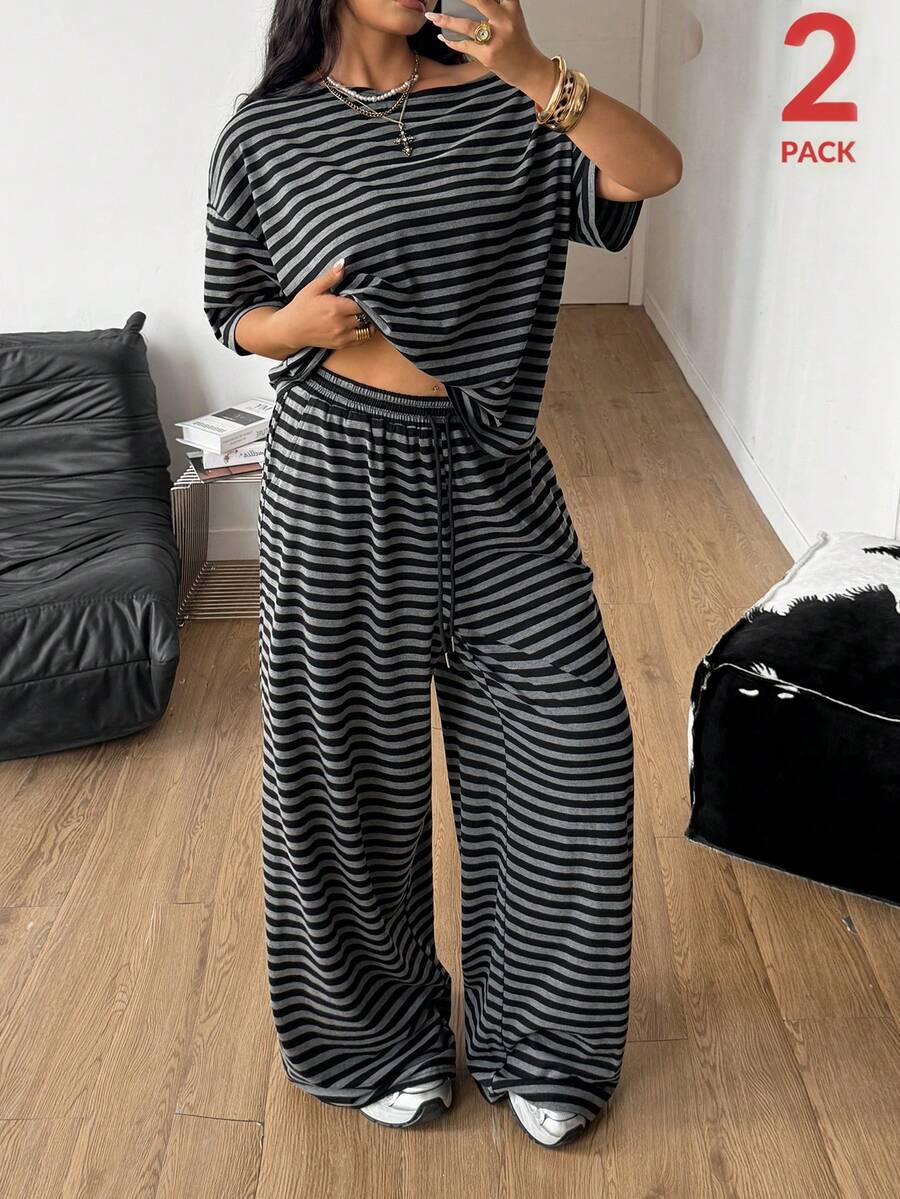 Women's casual two-piece outfit featuring a loose short-sleeve asymmetrical neck t-shirt and matching long wide leg pants with pockets.