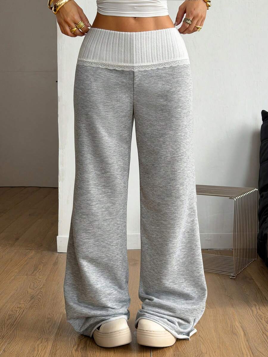 Women's wide leg flare sweatpants featuring a black and white colorblock contrast fold waistband and side stripe details.