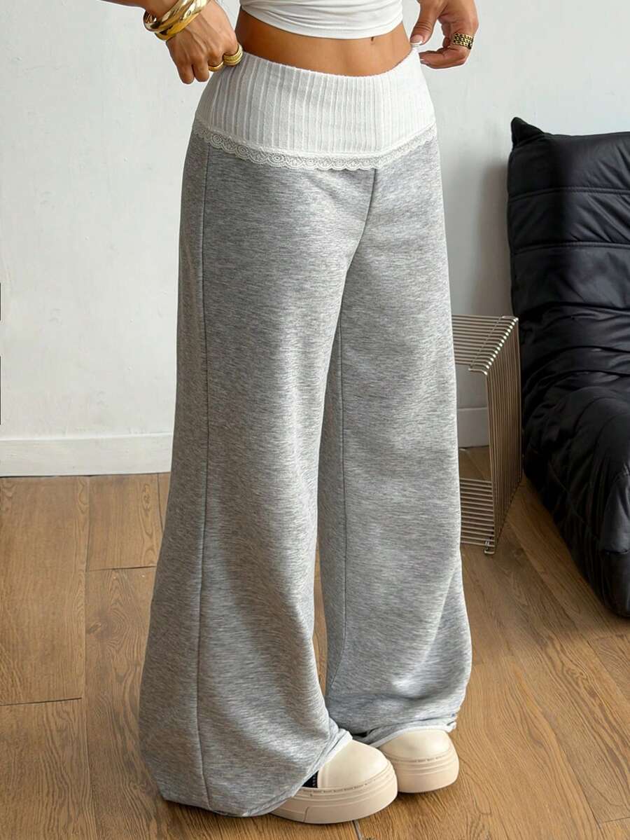 Women's wide leg flare sweatpants featuring a black and white colorblock contrast fold waistband and side stripe details.