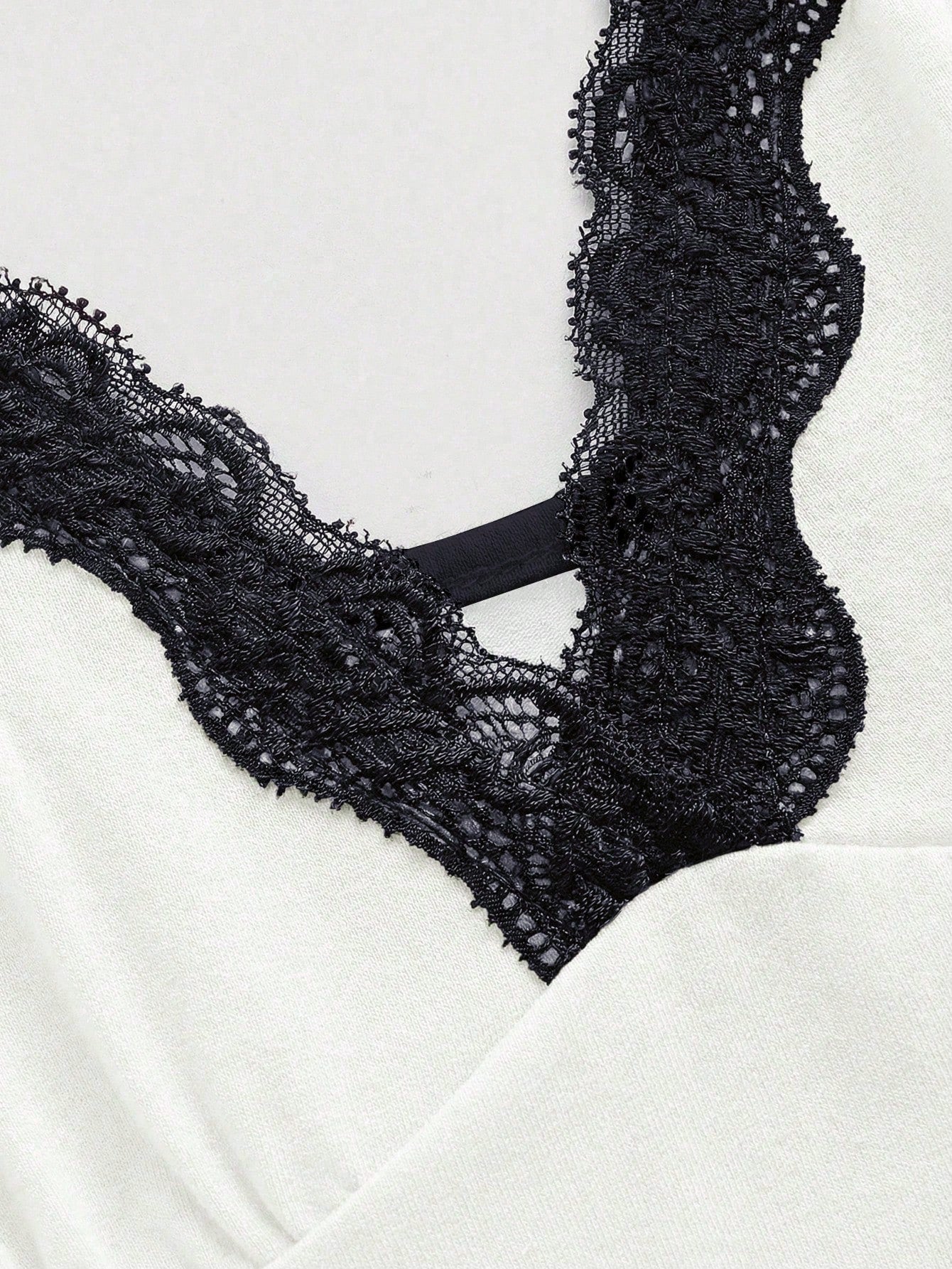 Women's spaghetti strap camisole with contrast lace patchwork, slim fit silhouette, plain design, and flared hem.