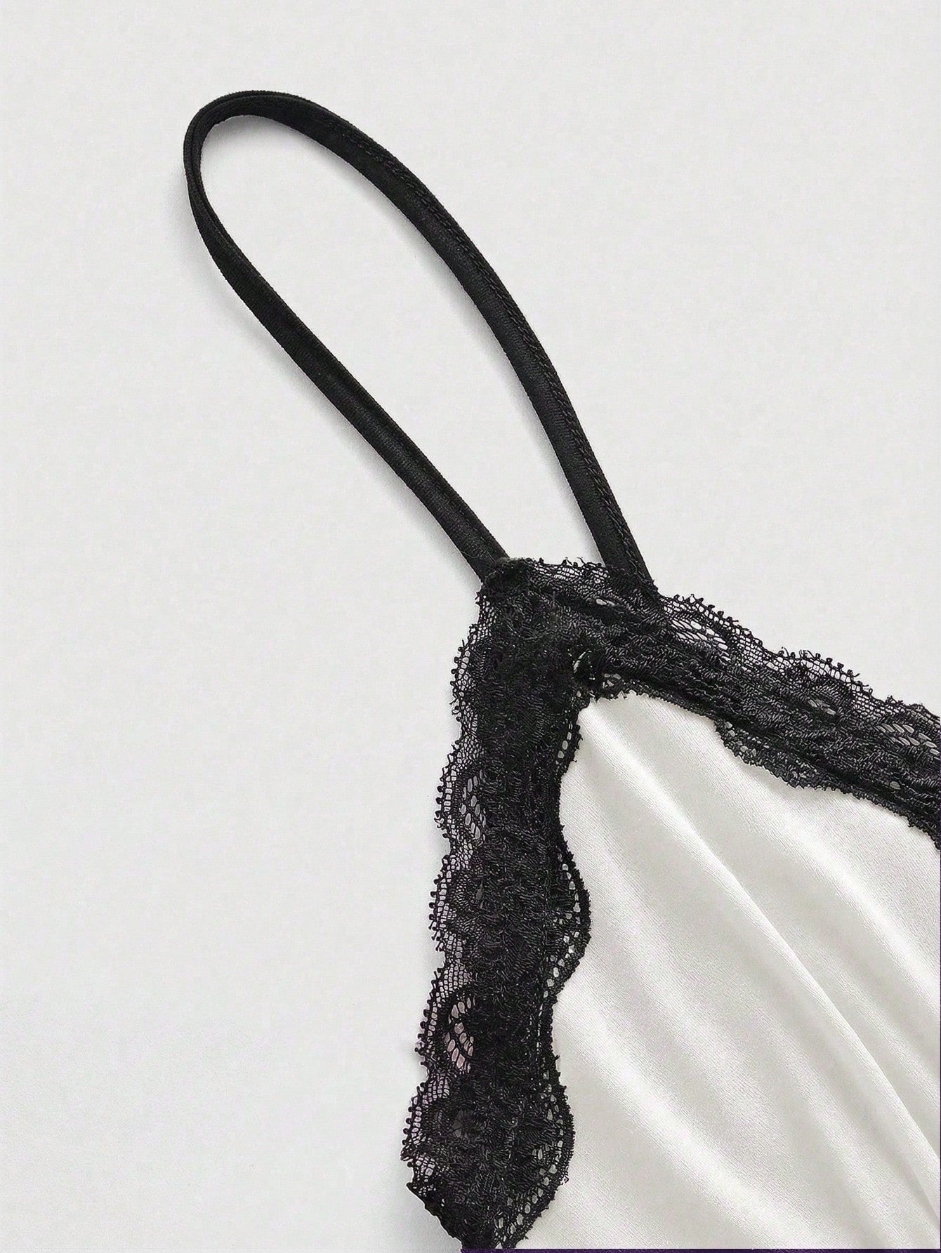 Women's spaghetti strap camisole with contrast lace patchwork, slim fit silhouette, plain design, and flared hem.