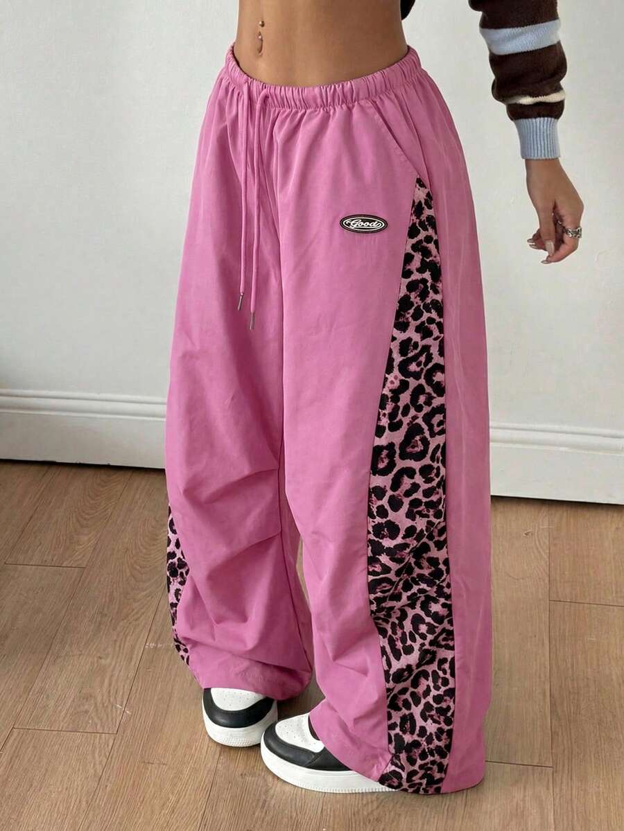 Women's black baggy jogger pants with an adjustable drawstring waist and colorblock polka dot geometric pattern.