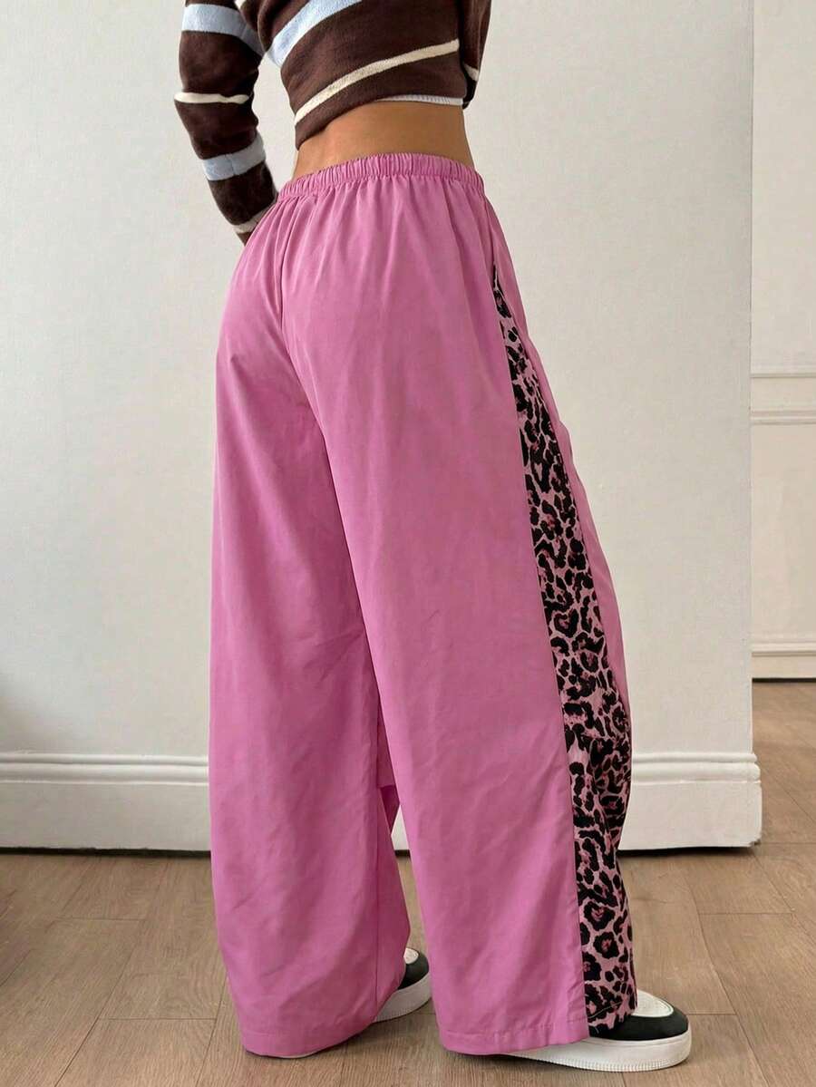 Women's black baggy jogger pants with an adjustable drawstring waist and colorblock polka dot geometric pattern.