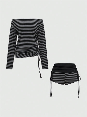 Women's black striped off-the-shoulder top with ruched drawstring knot detailing and extra-long sleeves.