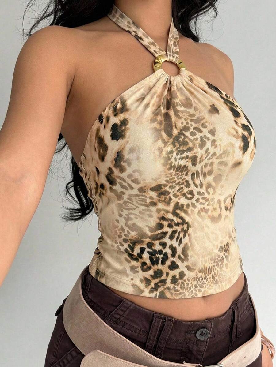Women's black backless halter mesh crop top featuring knot and ring details with matching arm sleeves.