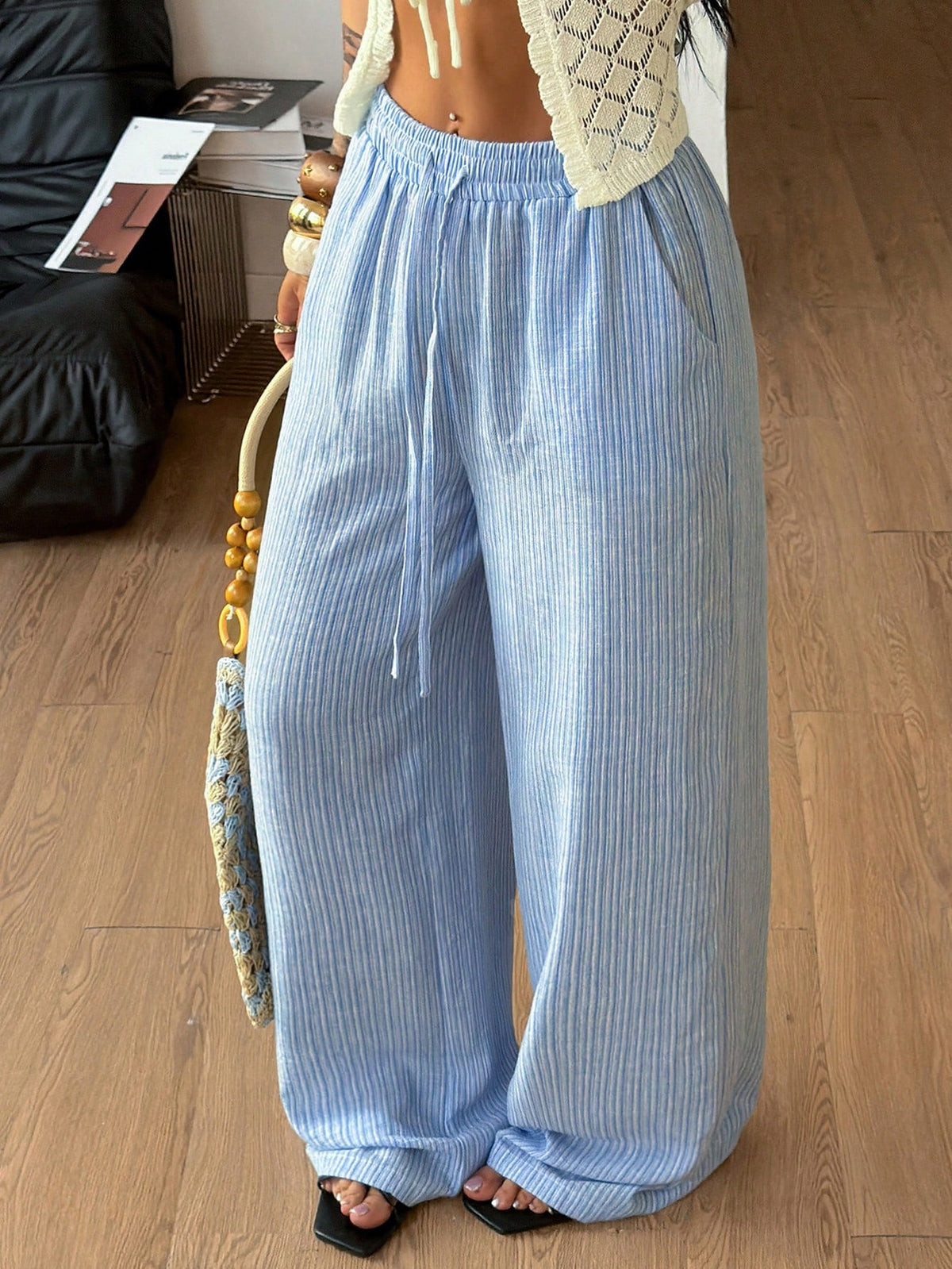 Women's loose straight leg cotton pants featuring a high waist with an adjustable drawstring knot and functional side pockets.