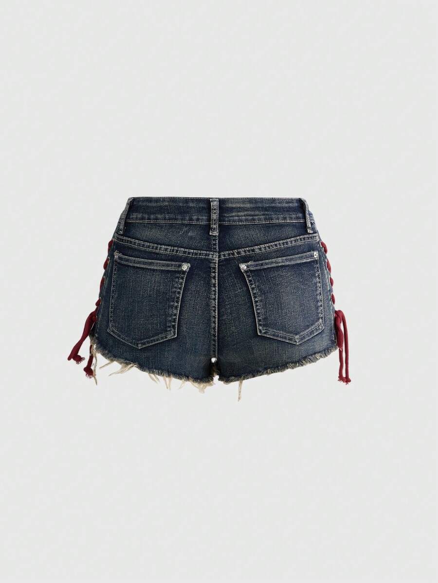 Women's Y2K low waist camo mini skort shorts featuring lace-up knot details, grommet eyelets, graphic lettering pattern, and a zipper fly.