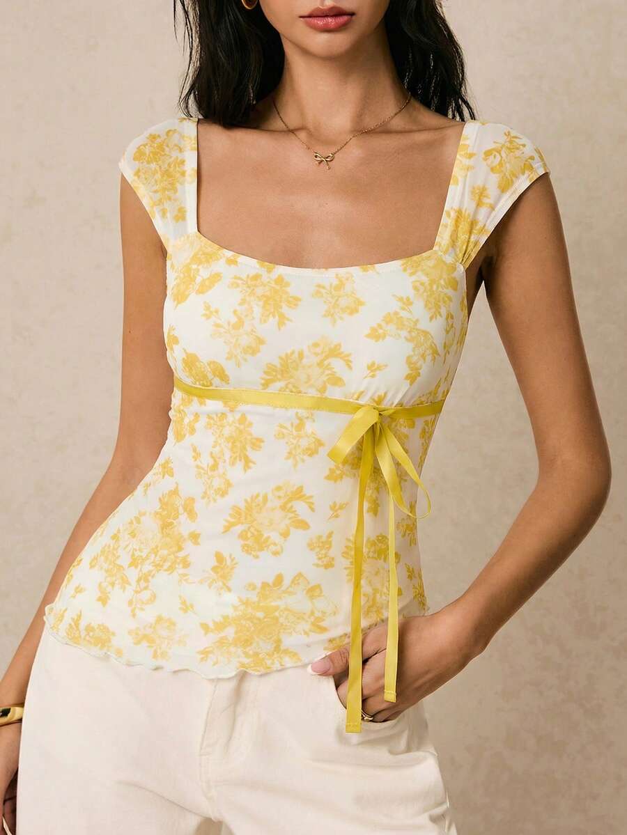 Women's dusty pink floral print mesh tank top featuring a square neckline, ruched bust with a tie-front knot, and an asymmetrical hem.