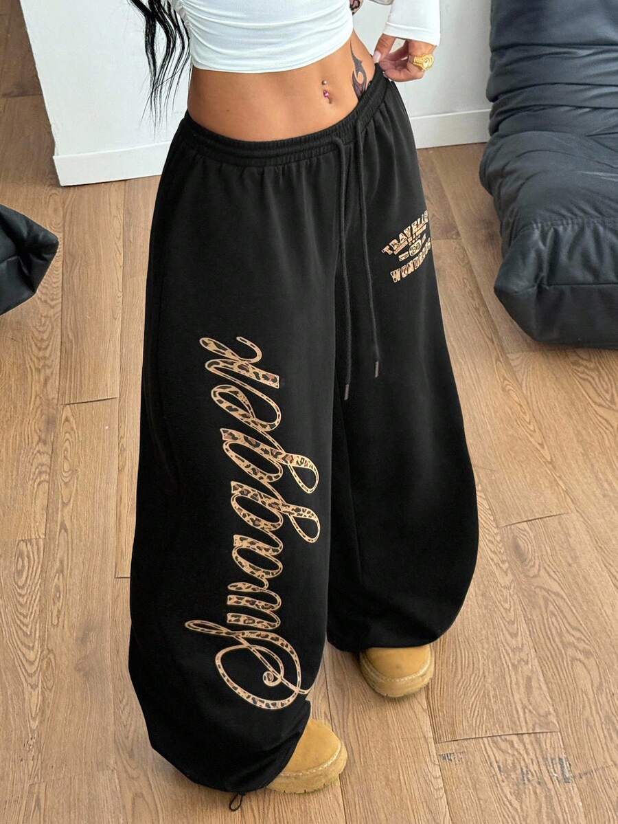 Women's loose fit wide leg graphic sweatpants in light grey with an elastic drawstring waistband