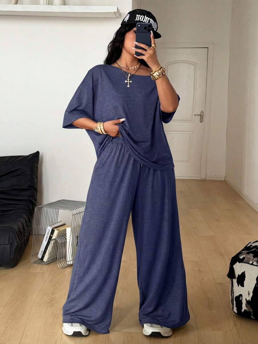 Women's casual two-piece outfit featuring a loose short-sleeve asymmetrical neck t-shirt and matching long wide leg pants with pockets.
