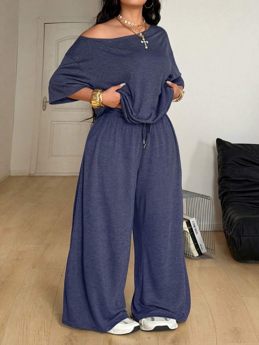 Women's casual two-piece outfit featuring a loose short-sleeve asymmetrical neck t-shirt and matching long wide leg pants with pockets.