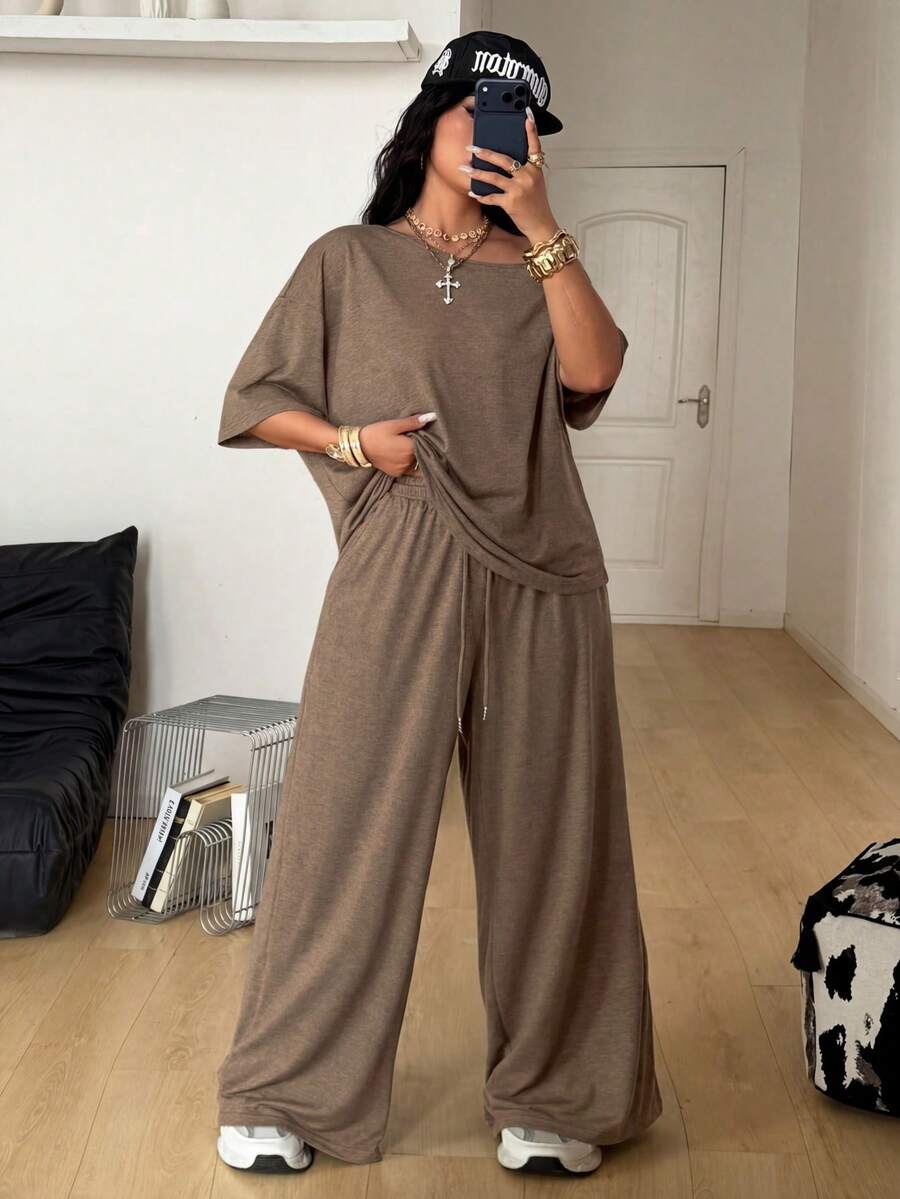 Women's casual two-piece outfit featuring a loose short-sleeve asymmetrical neck t-shirt and matching long wide leg pants with pockets.