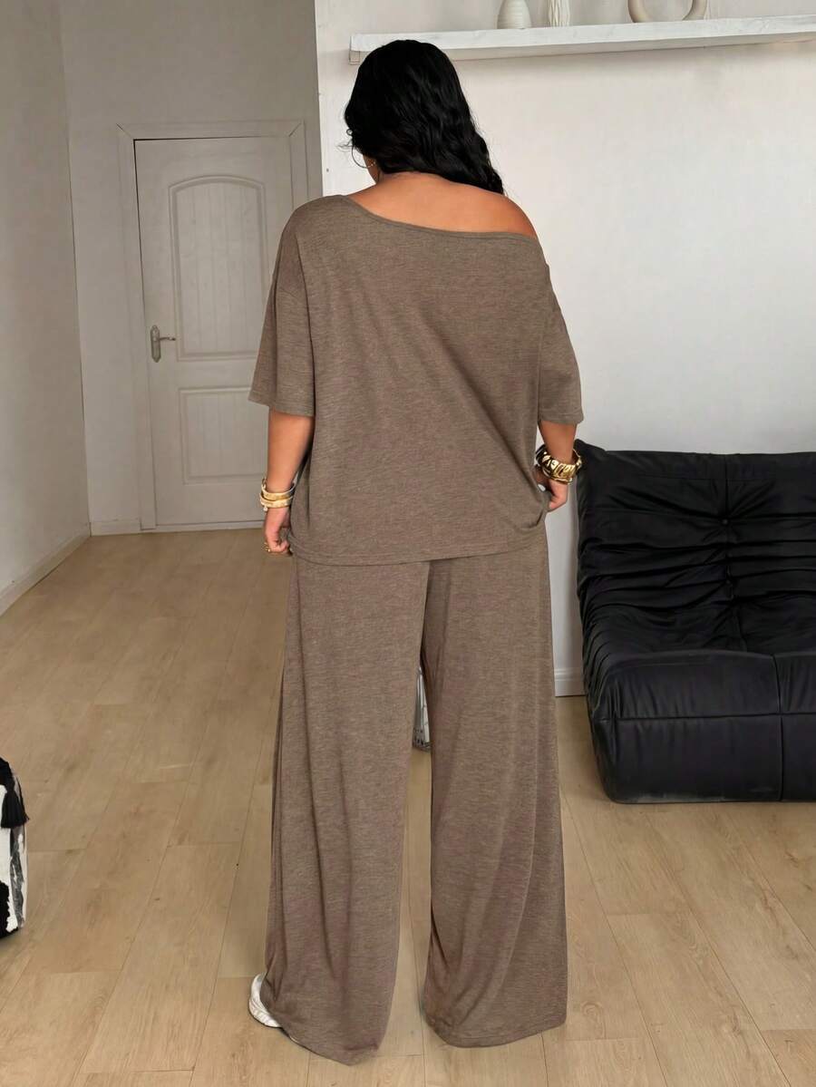 Women's casual two-piece outfit featuring a loose short-sleeve asymmetrical neck t-shirt and matching long wide leg pants with pockets.