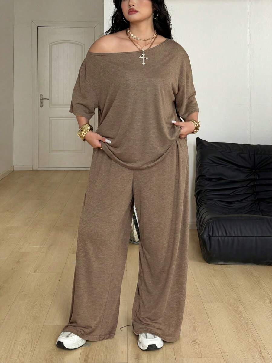 Women's casual two-piece outfit featuring a loose short-sleeve asymmetrical neck t-shirt and matching long wide leg pants with pockets.