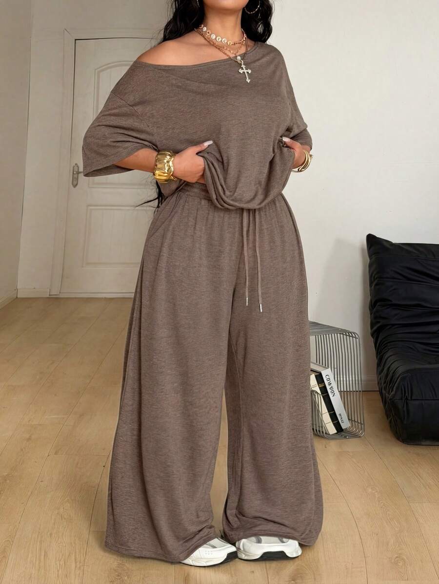 Women's casual two-piece outfit featuring a loose short-sleeve asymmetrical neck t-shirt and matching long wide leg pants with pockets.