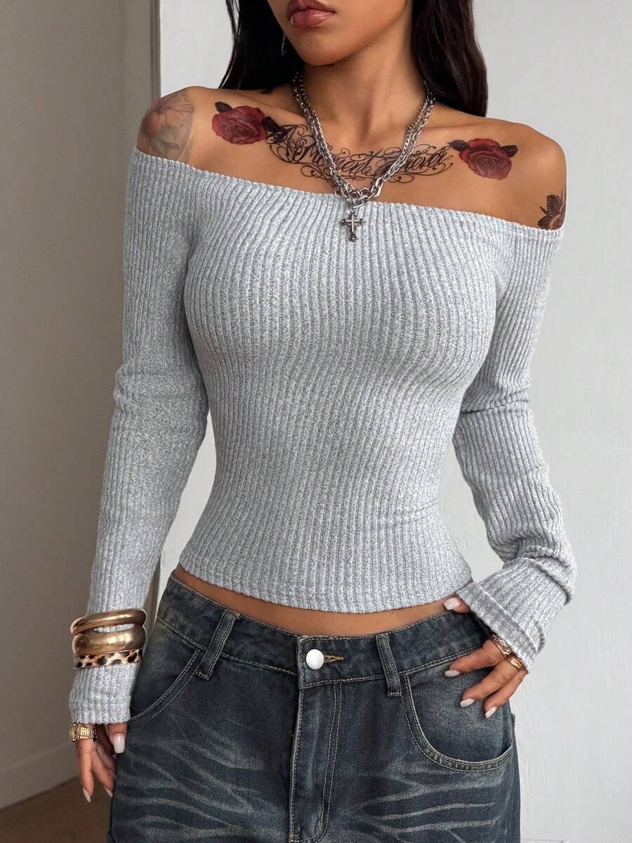 Slim fit women's cold shoulder long sleeve top in black featuring a faux fur hood, ribbed knit texture, and grommet accents.