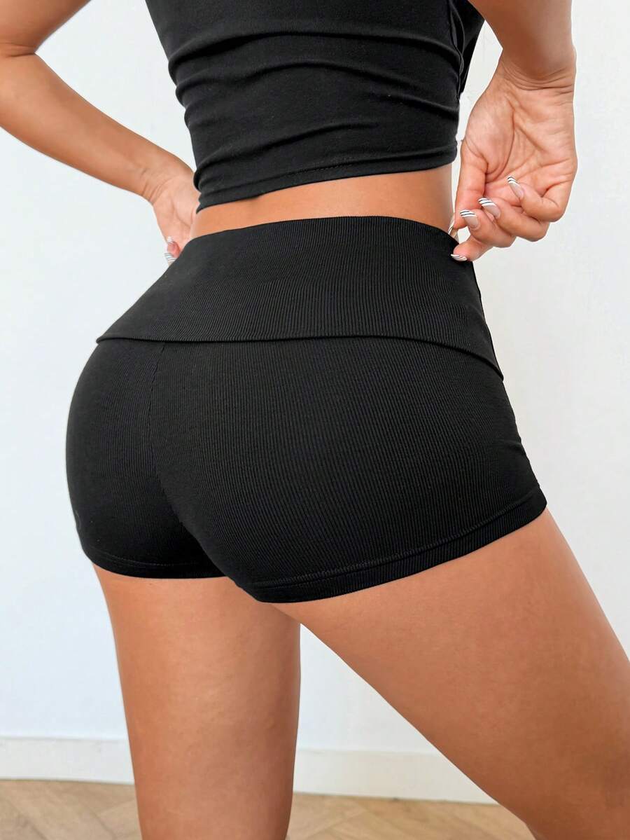Women's black ultra low rise mini shorts with grommet eyelet and rib-knit details, zipper fly closure, skinny straight-leg fit, and plain knitted fabric.